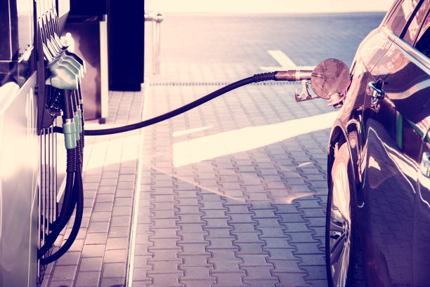 一辆停在加油站的汽车，将一根软管从油柱插入油箱图片下载