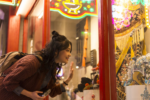 年轻的中国女大学生惊叹于京剧服装和头饰的橱窗-库存照片图片下载