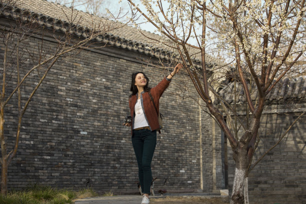 年轻的中国女大学生在一个四合院的房子外面的照片图片下载