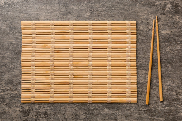 两根筷子和竹垫在水泥背景上。俯视图，复制空间图片下载