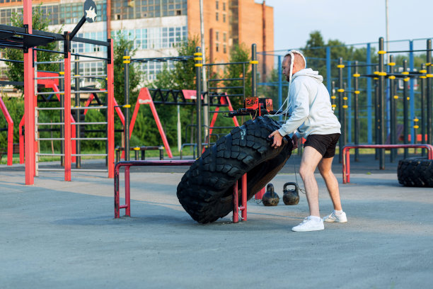 一个留着胡子、发型有趣的男人在做压胎练习(压着一个沉重的大轮胎)。图片下载