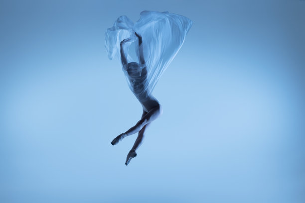 灵活的女人的肖像，优雅的芭蕾舞者与织物跳舞，布孤立在蓝色的工作室背景。优雅、艺术、美的理念。轻便,温柔。图片下载