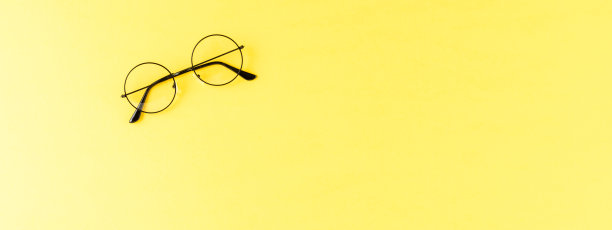 黄色背景的时尚眼镜。横幅图片下载