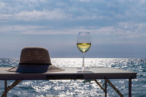 浪漫的白葡萄酒，在海滩上。在度假村品酒和放松图片下载