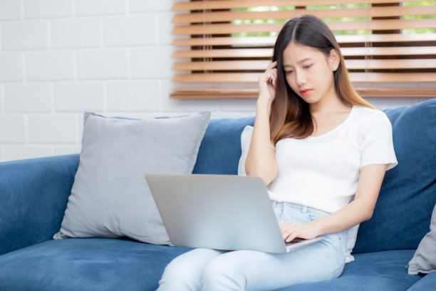 年轻的亚洲妇女工作在笔记本电脑在家里的沙发上沮丧和无聊，自由职业女孩不开心和疲倦的不成功，从问题，失败和错误，商业概念沮丧。图片下载