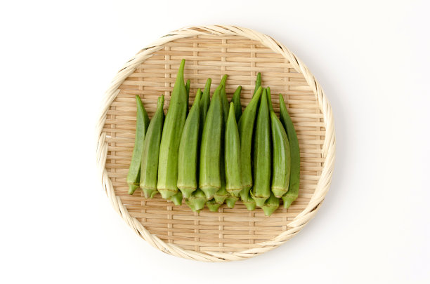 新鲜秋葵在竹筛白色背景图片下载
