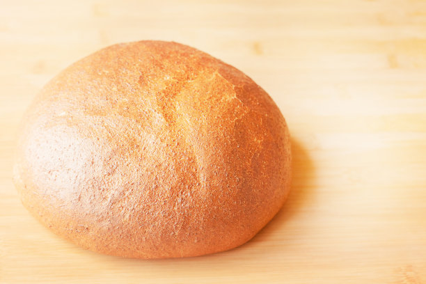 木桌上的一条圆形小麦面包。食物的照片。图片下载