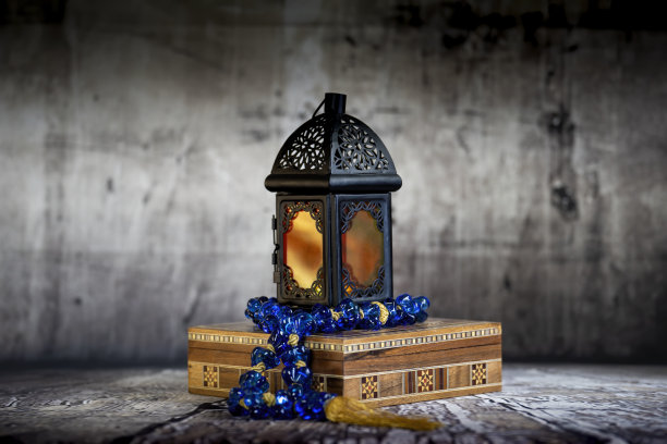 斋月灯笼点亮，在复古的气氛或环境中，阿拉伯花盒上挂着一串蓝色的阿拉伯念珠。图片下载