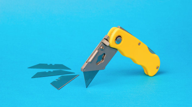 折叠刀切刀和三个备用刀片在蓝色背景。图片下载
