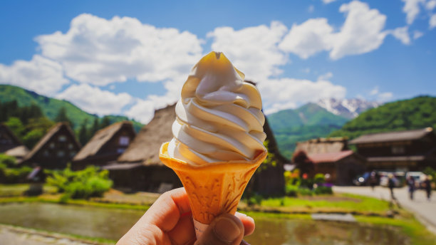 手持香草冰淇淋蛋筒的特写。图片下载