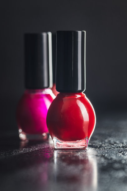 黑色的桌子上放着彩色的指甲油瓶子。图片下载