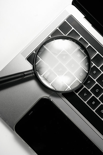 电脑，手机和放大镜在白色背景板上图片下载