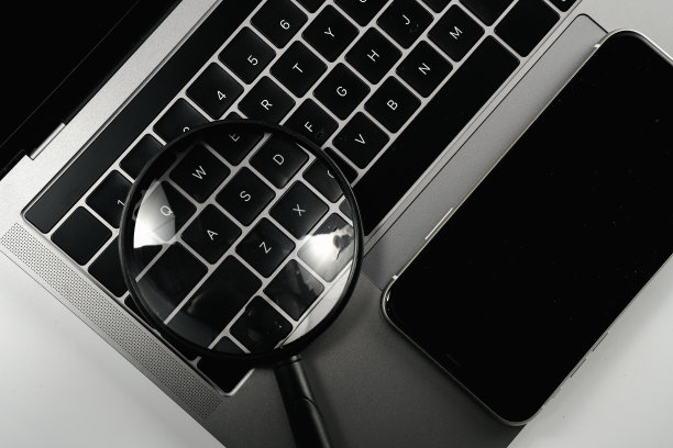 电脑，手机和放大镜在白色背景板上图片下载