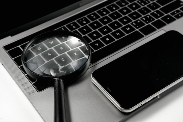 电脑，手机和放大镜在白色背景板上图片下载
