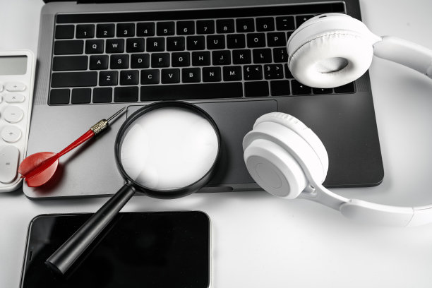 电脑在白色背景板，放大镜，飞镖，耳机和计算器图片下载