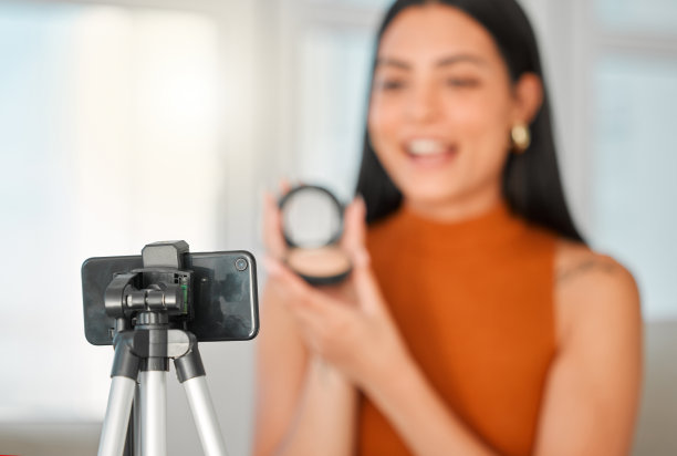 剪裁镜头的一个有吸引力的年轻美貌影响者直播从她的客厅在家里图片下载