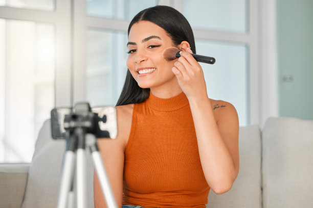 剪裁镜头的一个有吸引力的年轻美貌影响者直播从她的客厅在家里图片下载