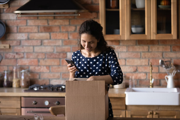 微笑的拉丁女收信人拍摄开箱包裹在蜂窝网络摄像头图片下载