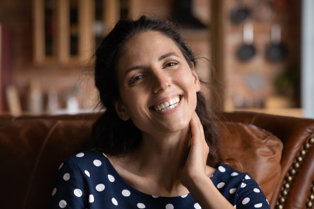 快乐快乐的年轻女性看着相机在家里摆姿势图片下载