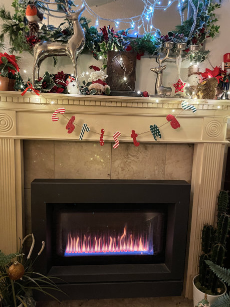 现代燃气壁炉的特写图像与圣诞装饰在现代休息室客厅家庭内部，火焰线图片下载