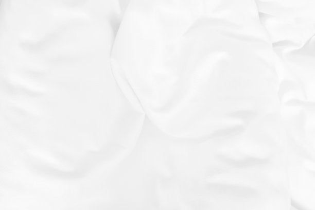 近距离俯视图白色被单和皱褶凌乱的毛毯在早上醒来后的卧室。图片下载