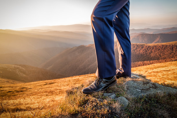 男人的脚穿着黑色经典鞋在山上图片下载