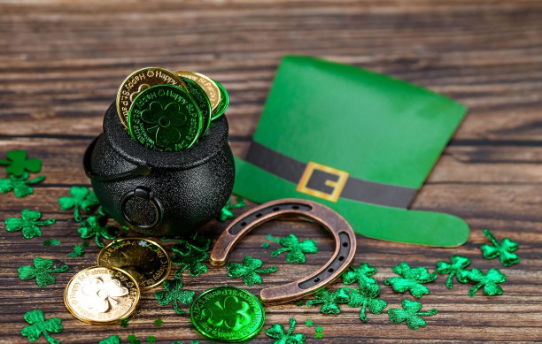 3月17日圣帕特里克节的白色复古日历，木制背景上有一个幸运的马蹄铁和一罐金子。图片下载