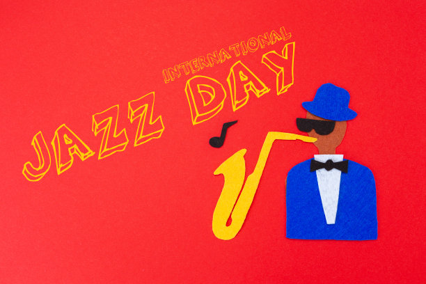 一个音乐家的剪影，在红色的背景上，用毛毡剪出萨克斯风的旋律。平的。世界爵士日图片下载