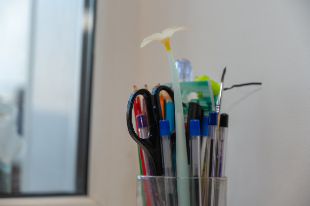 在玻璃烧杯里画画用的铅笔、钢笔、刷子。书写和绘画的办公或学习用品。图片下载