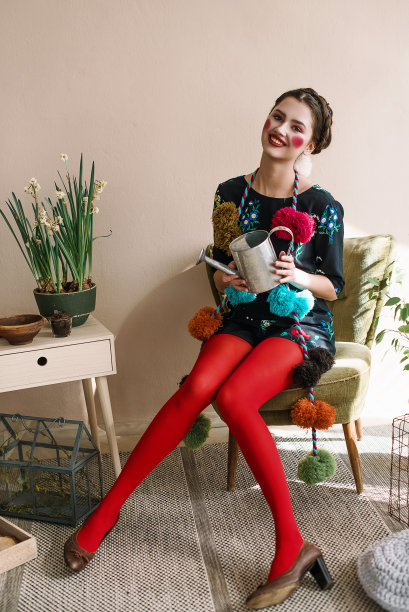 时尚美丽的黑发女孩在连体衣花卉刺绣与彩色化妆:红色的脸颊和嘴唇有乐趣，浇花。奶奶别致的风格。过肖像图片下载