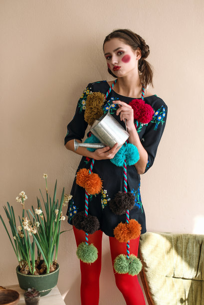 时尚美丽的黑发女孩在连体衣花卉刺绣与彩色化妆:红色的脸颊和嘴唇有乐趣，浇花。奶奶别致的风格。过肖像图片下载