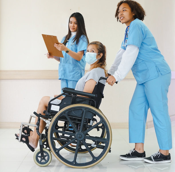 在康复中心，女护士推着轮椅上的残疾妇女。图片下载