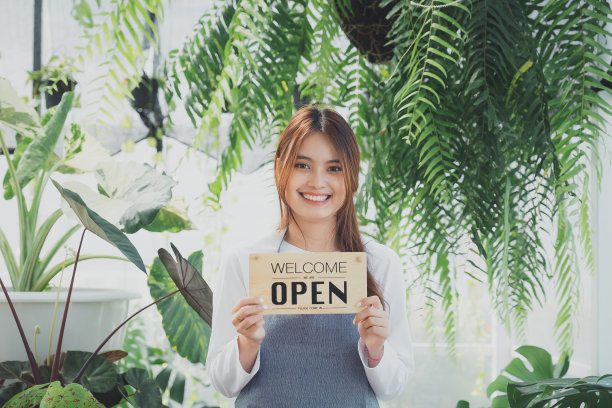店主站在街市摊位上，心情愉快。图片下载