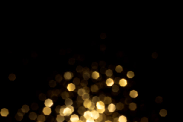 黑色背景上的金色模糊散景灯光图片下载
