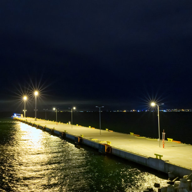 美丽的码头在明亮的灯光下闪烁夜空概念景观。爱沙尼亚的海洋图片下载