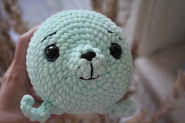 美丽可爱的针织玩具薄荷色印章在室内柔和的颜色在手上和没有手图片下载