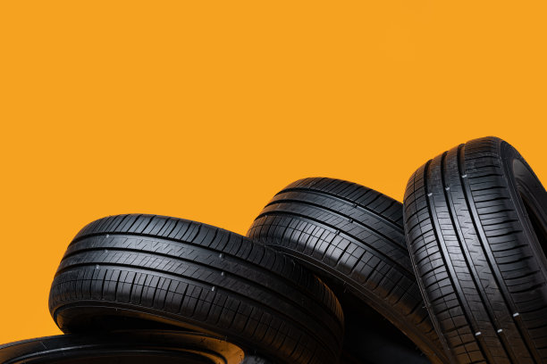 黄色背景上孤立的汽车轮胎，特写图片下载