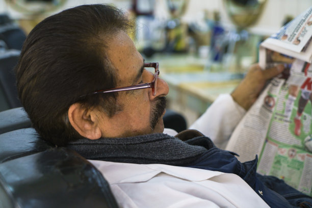 拍摄的是一位老人在看报纸图片下载