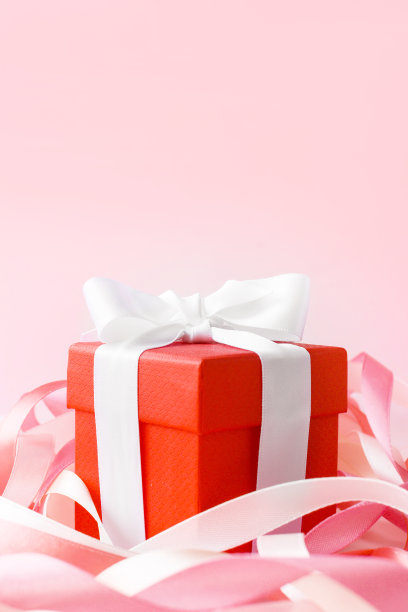 母亲节快乐或国际家庭日。妇女节快乐。情人节。一个红色的盒子，里面装着用节日丝带装饰的礼物。横幅的商店。贺卡。本空间图片下载
