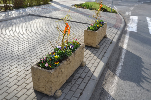 观赏花盆在村庄中心槽混凝土花盆与美丽的装饰紫罗兰和水仙。复活节即将来临，所以有必要装饰家里的入口，停车场图片下载