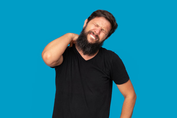 英俊的大胡子男人，蓝色背景的颈部和腰部疼痛图片下载