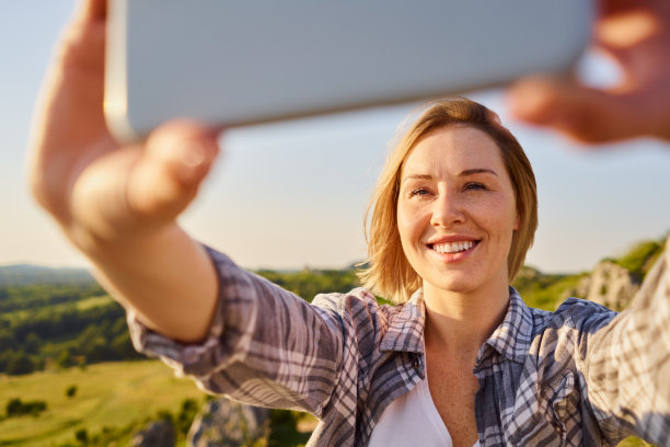 年轻女子的特写照片，在阳光明媚的夏天远足在农村自拍图片下载