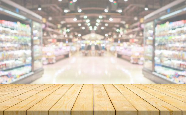 空的木头桌面与超市杂货店通道和货架模糊的背景图片下载