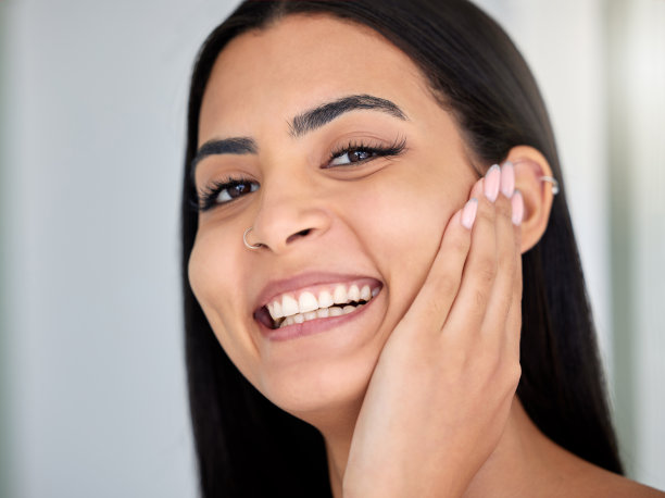 这张照片拍摄的是一个年轻女人在家里的浴室里做她的日常护肤图片下载