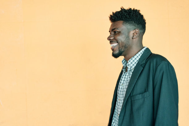 快乐的情绪。大笑的非裔美国人的肖像在黄色背景摆姿势，欢快的年轻卷曲的黑人男子有乐趣，有好心情，侧视图拍摄，复制空间图片下载