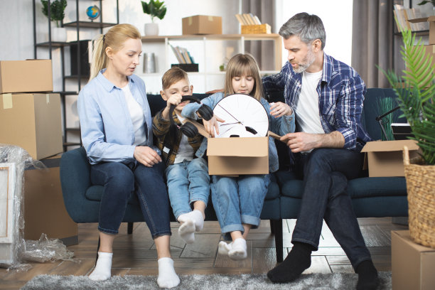两个孩子帮父母收拾搬家用的箱子图片下载