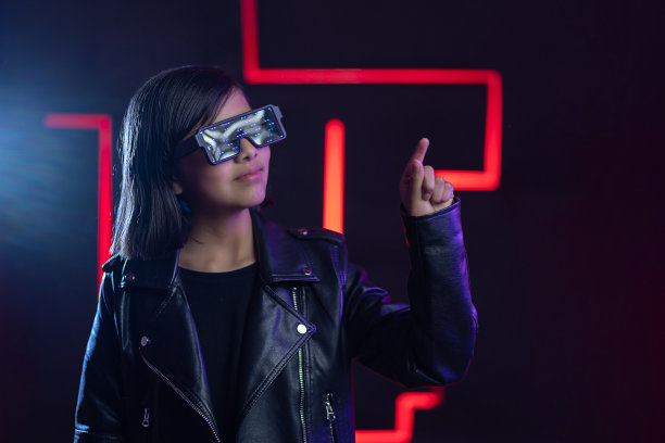 赛博朋克玩家，戴着未来主义眼镜，靠近红色霓虹灯，虚拟现实和元宇宙概念图片下载