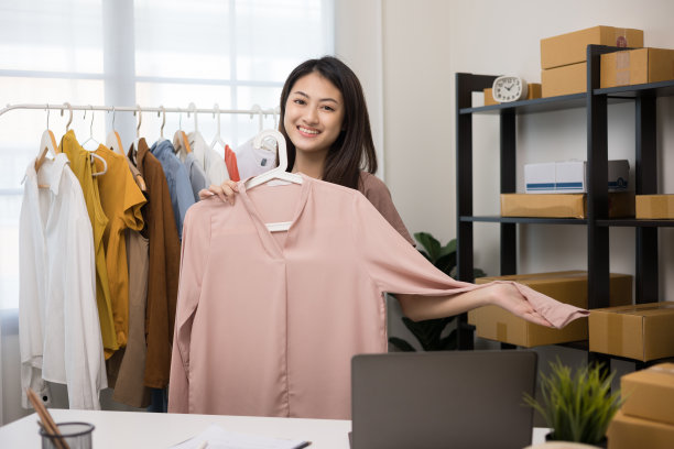 亚洲女性选择许多衣服挂在栏杆上，并试衣服。女人在时装店买衣服。寻找t恤或裙子，并在店里进行试穿图片下载