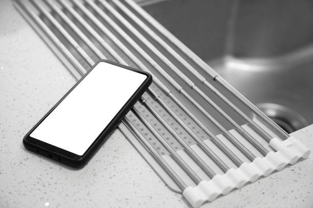 家庭厨房的水槽旁边放着一部空白屏幕的智能手机图片下载