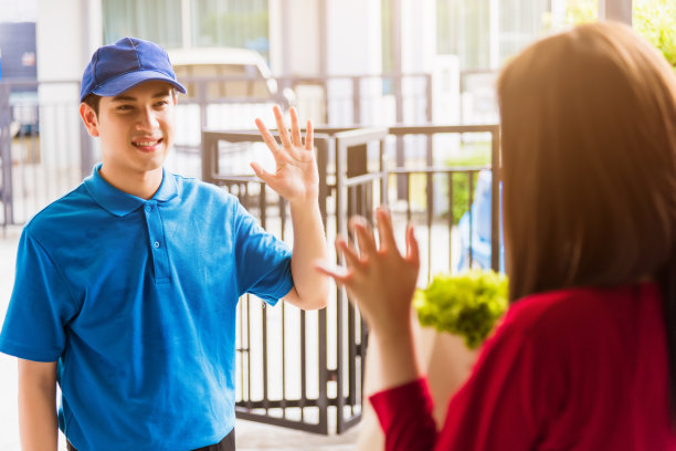 送货员在杂货店给女顾客送纸袋里的新鲜蔬菜图片下载